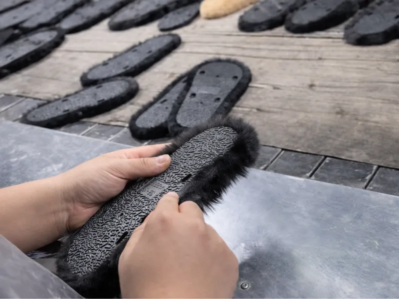 Manual surface finishing during plush slipper production