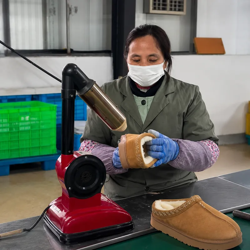 Worker using controlled heat finishing to refine plush slipper surface before packing